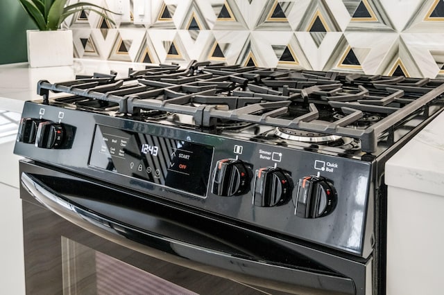 room details featuring black range with gas stovetop and backsplash