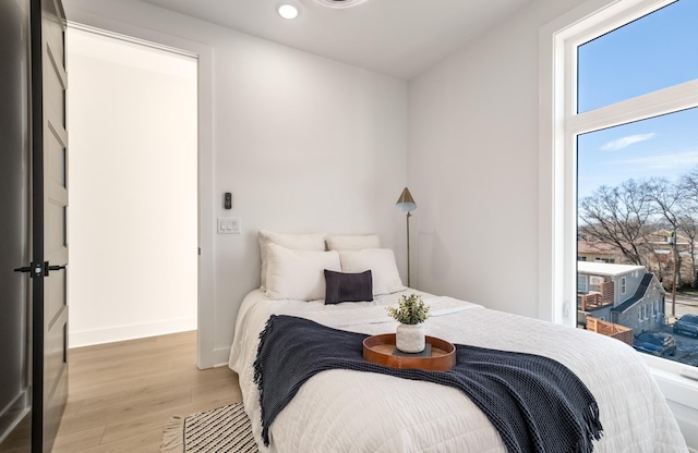 bedroom featuring light wood finished floors, recessed lighting, and baseboards