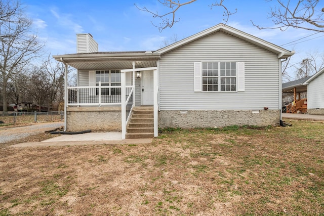 view of front of property with a chimney, a porch, crawl space, fence, and a front lawn