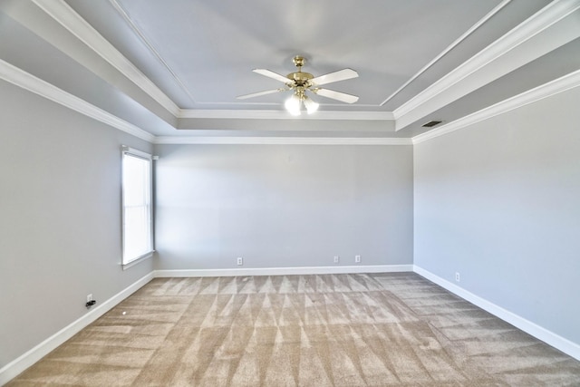 carpeted spare room featuring ornamental molding, a raised ceiling, and visible vents