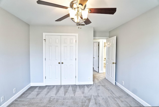 unfurnished bedroom featuring ceiling fan, baseboards, a closet, and carpet flooring