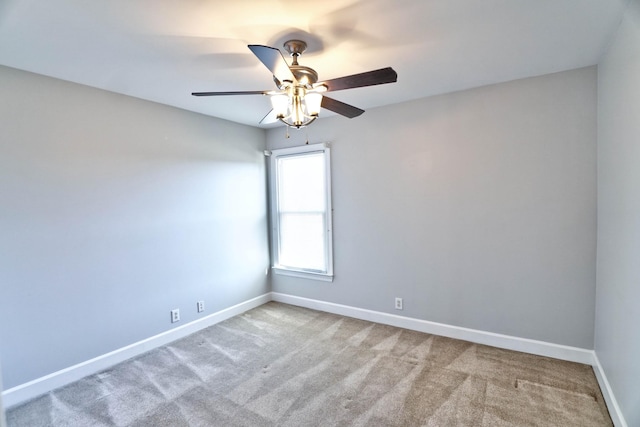 carpeted empty room featuring a ceiling fan and baseboards