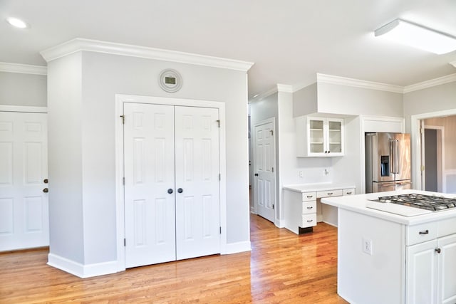 kitchen with stainless steel appliances, light countertops, glass insert cabinets, and white cabinets