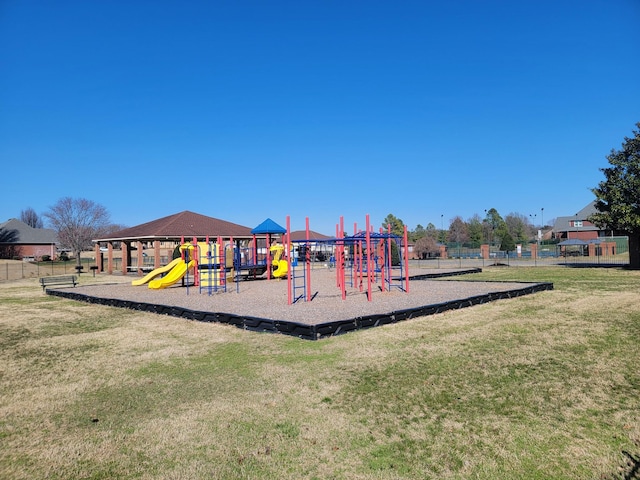 community jungle gym featuring fence and a lawn