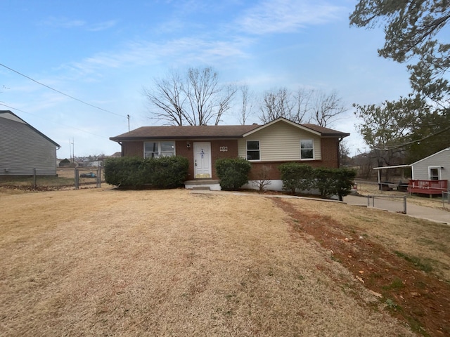 ranch-style home with fence, a front lawn, and brick siding