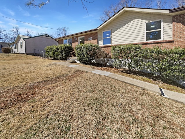 ranch-style home featuring a front yard and brick siding