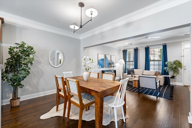 dining area with ornamental molding, dark wood-type flooring, ceiling fan, and baseboards