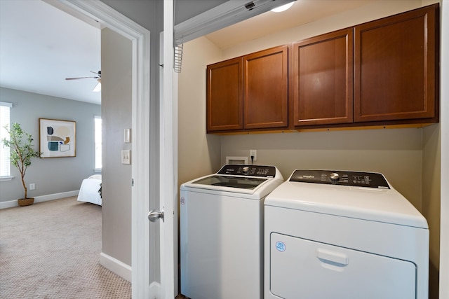 washroom featuring ceiling fan, light colored carpet, separate washer and dryer, baseboards, and cabinet space