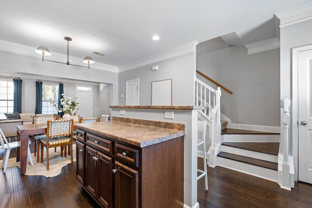 kitchen featuring crown molding, dark wood finished floors, light countertops, dark brown cabinetry, and baseboards