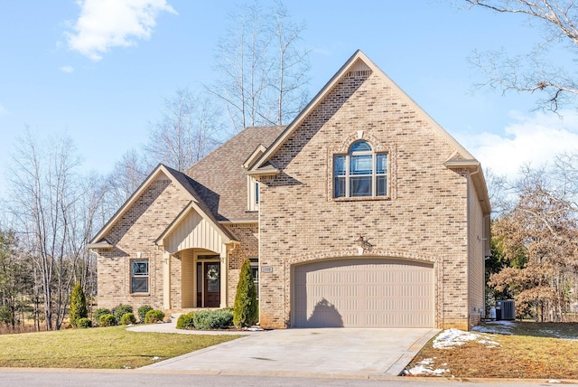 view of front of house with driveway, central air condition unit, a garage, and brick siding