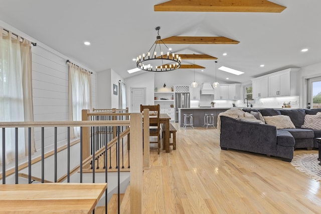 living room with a skylight, light wood-type flooring, high vaulted ceiling, beam ceiling, and recessed lighting