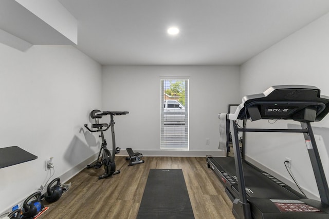 exercise area featuring dark wood-style flooring and baseboards