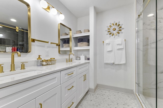 bathroom with double vanity, a sink, a marble finish shower, and baseboards