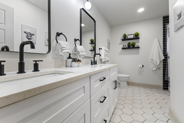 bathroom with double vanity, toilet, a sink, and recessed lighting