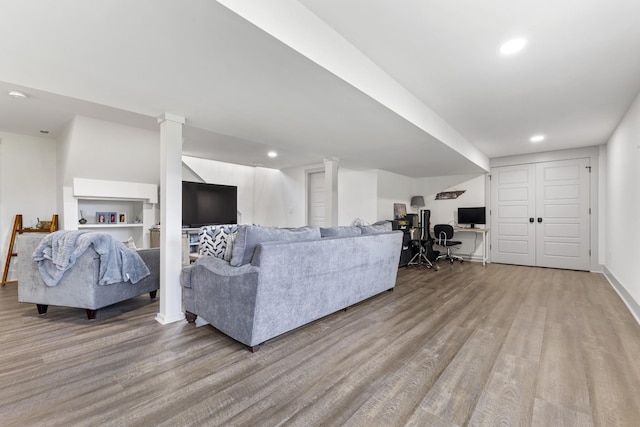 living room with light wood-style flooring, decorative columns, and recessed lighting