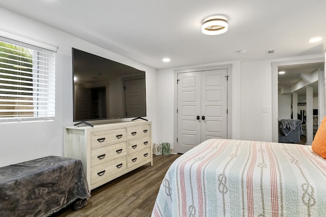 bedroom featuring a closet, dark wood-style flooring, and recessed lighting