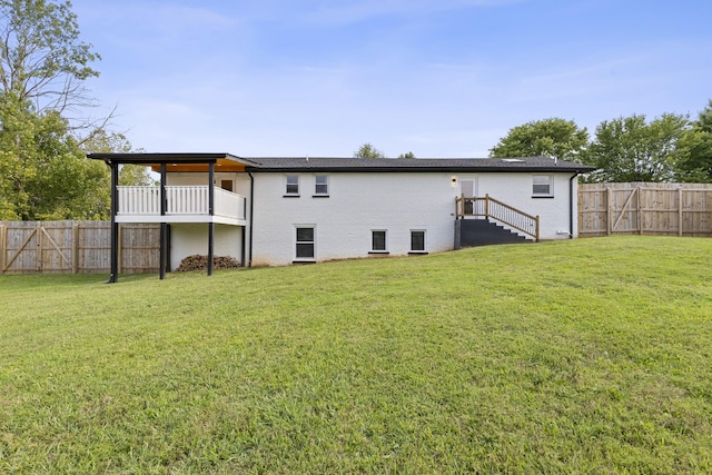 back of house featuring brick siding, a lawn, and a fenced backyard