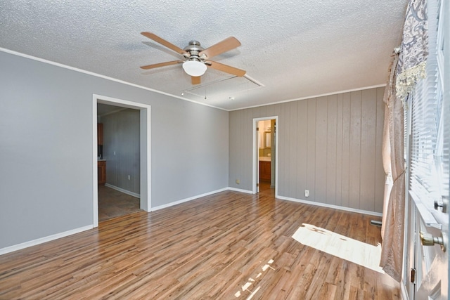 interior space featuring crown molding, attic access, a ceiling fan, a textured ceiling, and light wood-type flooring