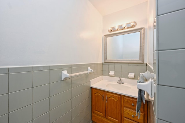 bathroom with a wainscoted wall, tile walls, and vanity