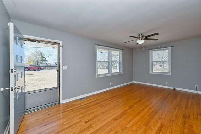 interior space with baseboards, visible vents, ceiling fan, and wood finished floors