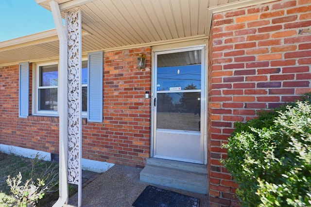 view of exterior entry with brick siding