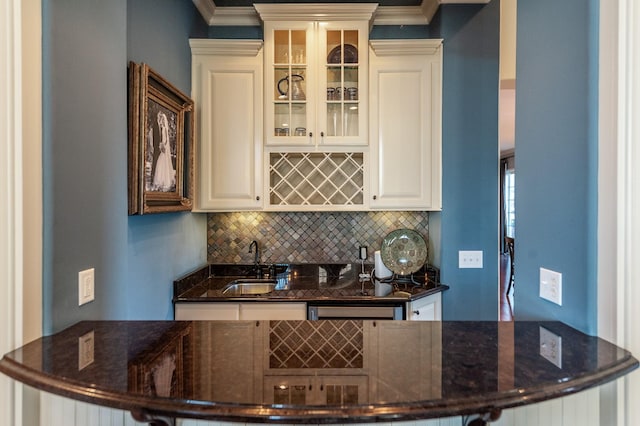 bar featuring ornamental molding, backsplash, and a sink