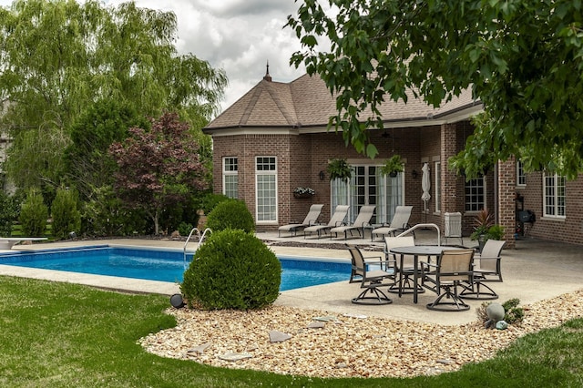 outdoor pool featuring a patio area and a diving board