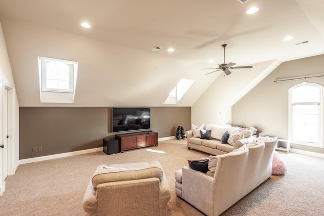 living room with lofted ceiling with skylight, carpet, visible vents, and baseboards