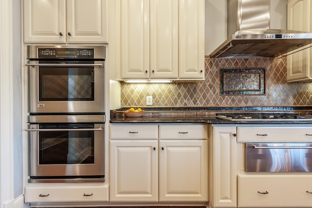 kitchen featuring extractor fan, stainless steel appliances, white cabinetry, a warming drawer, and tasteful backsplash