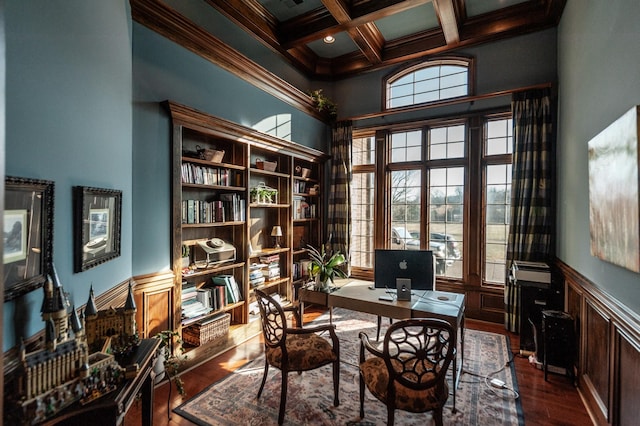 home office with coffered ceiling, wood finished floors, ornamental molding, wainscoting, and beamed ceiling