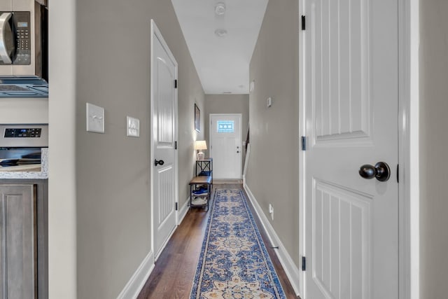 doorway to outside featuring dark wood-style flooring and baseboards