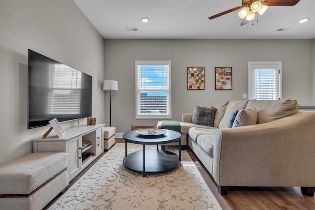 living area with dark wood-style flooring, recessed lighting, visible vents, and a ceiling fan