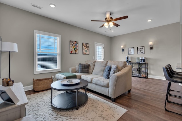 living room featuring recessed lighting, visible vents, baseboards, and wood finished floors