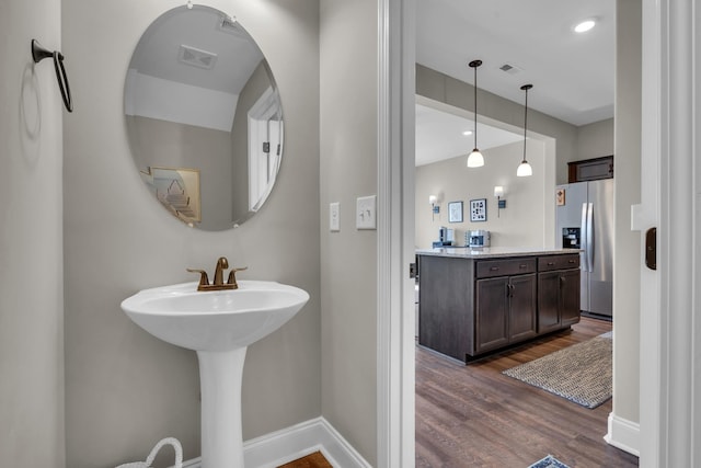 bathroom featuring wood finished floors, visible vents, and baseboards