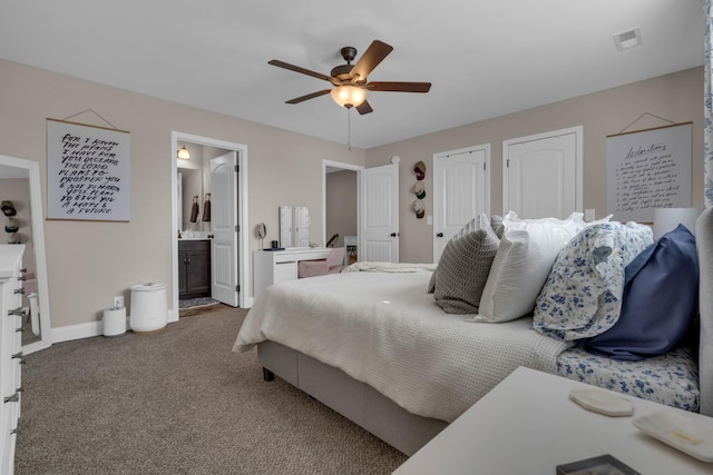 bedroom featuring multiple closets, visible vents, carpet flooring, connected bathroom, and baseboards