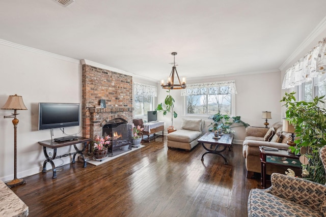 living room with a notable chandelier, baseboards, a brick fireplace, dark wood-style floors, and crown molding