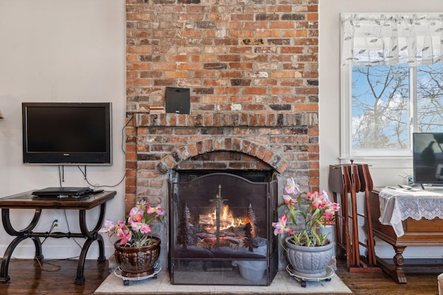 room details with a brick fireplace, baseboards, and wood finished floors