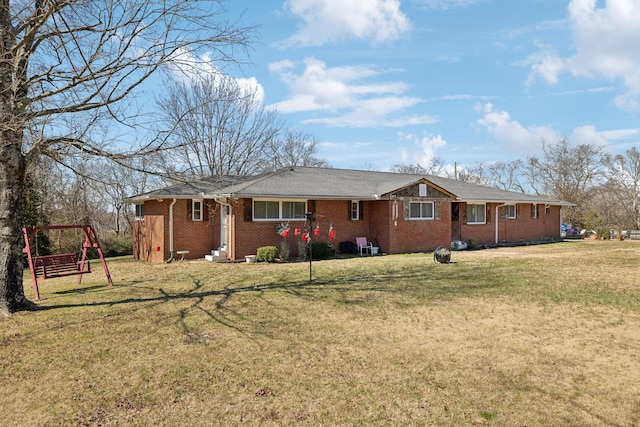 exterior space with brick siding, a lawn, and a playground