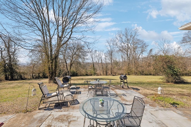 view of patio / terrace featuring outdoor dining area and a wooded view