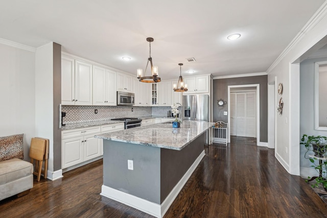 kitchen with glass insert cabinets, a kitchen island, appliances with stainless steel finishes, and white cabinets