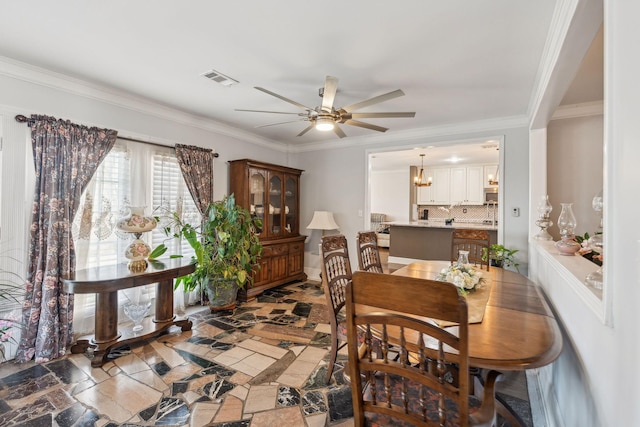 dining space featuring ceiling fan with notable chandelier, visible vents, and crown molding