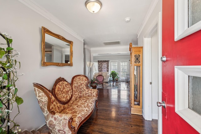 foyer featuring dark wood-style flooring, visible vents, and crown molding