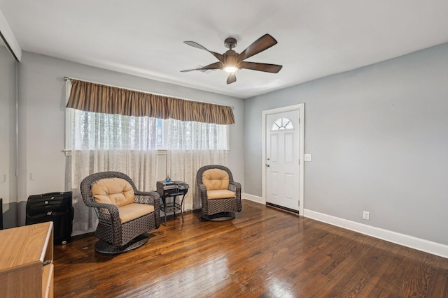 living area with dark wood finished floors, baseboards, and ceiling fan