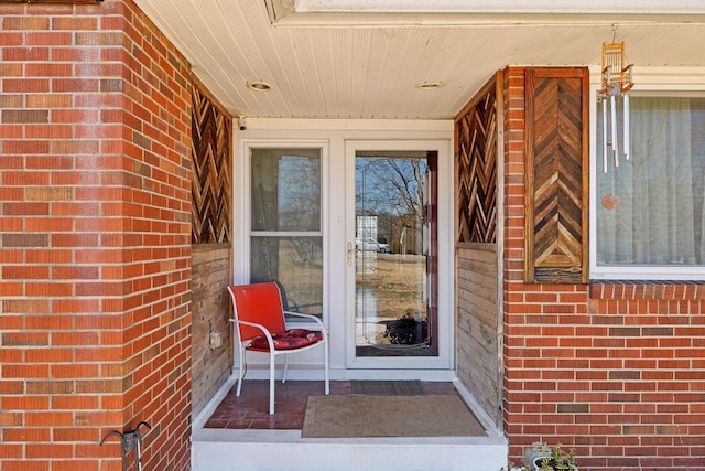 doorway to property featuring brick siding