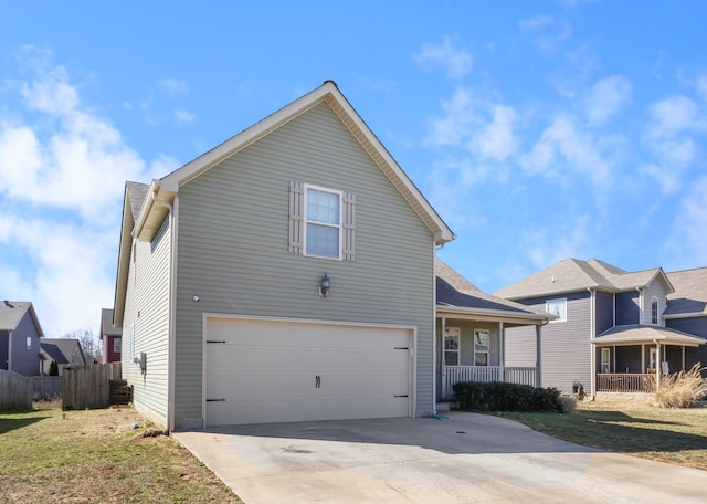 traditional-style home featuring driveway, an attached garage, covered porch, fence, and a front yard