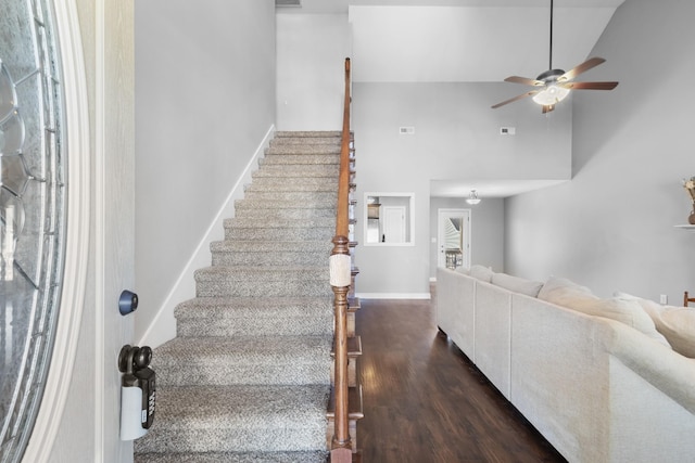 interior space featuring high vaulted ceiling, wood finished floors, a ceiling fan, and baseboards