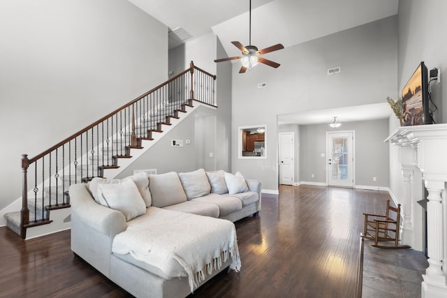 living area with dark wood-style floors, stairs, visible vents, and baseboards