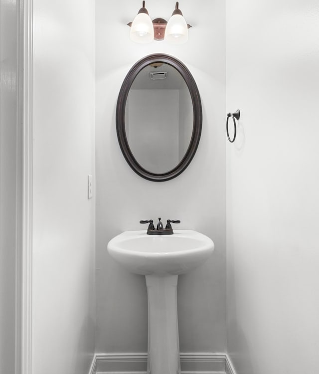 bathroom with a sink and baseboards