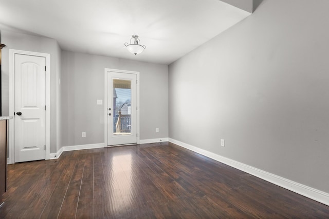 unfurnished room featuring dark wood-style floors and baseboards