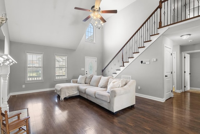 living room featuring dark wood-type flooring, a wealth of natural light, stairway, and baseboards